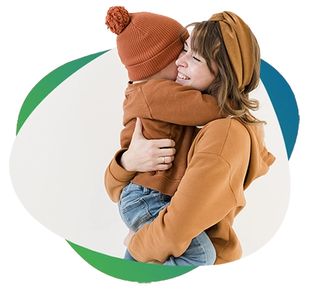 imagem de uma mãe, de roupa e lenço no cabelo caramelos, sorrindo e abraçada no filho, de toca e casaco marrons e calça jeans azul, sobre um fundo azul e verde escuros