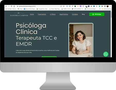 a tela inicial do site da sandra campos psicologia, com um fundo verde escuro com a foto da psicóloga, com informações em rosa e bege pastel, dentro de um monitor cinza